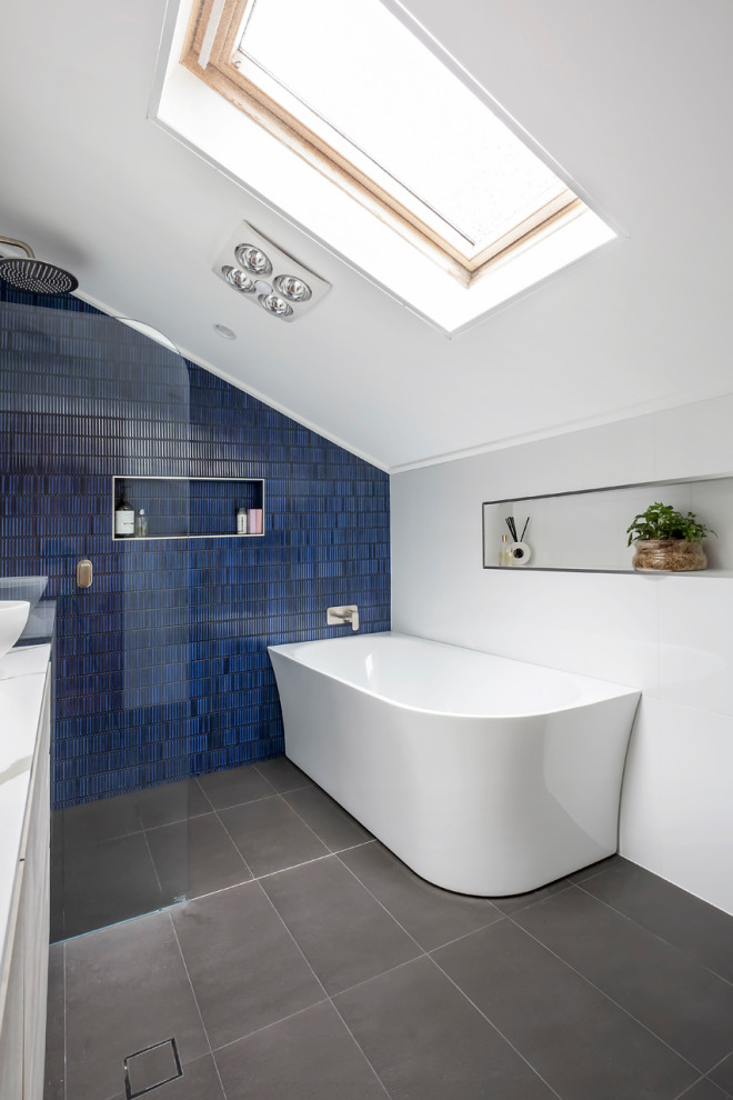 Inspiration for a mid-sized contemporary master wet room bathroom in Sydney with flat-panel cabinets, grey cabinets, a corner tub, a one-piece toilet, white tile, ceramic tile, a vessel sink, engineered quartz benchtops, an open shower, white benchtops, a double vanity and a freestanding vanity.