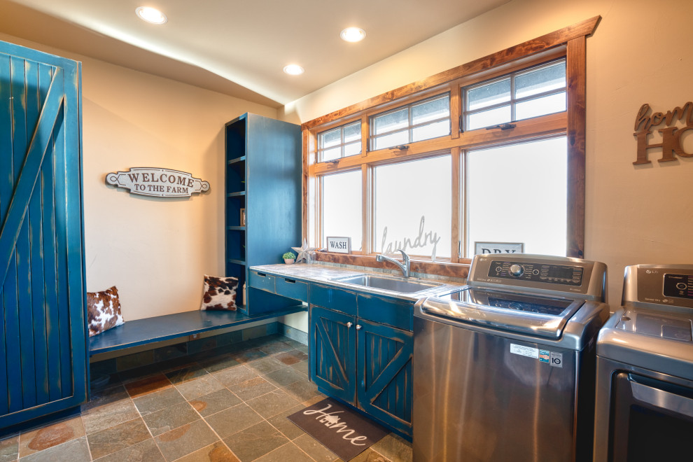 Large farmhouse l-shaped utility room in Other with a built-in sink, blue cabinets, beige walls, terracotta flooring, a side by side washer and dryer and multi-coloured floors.