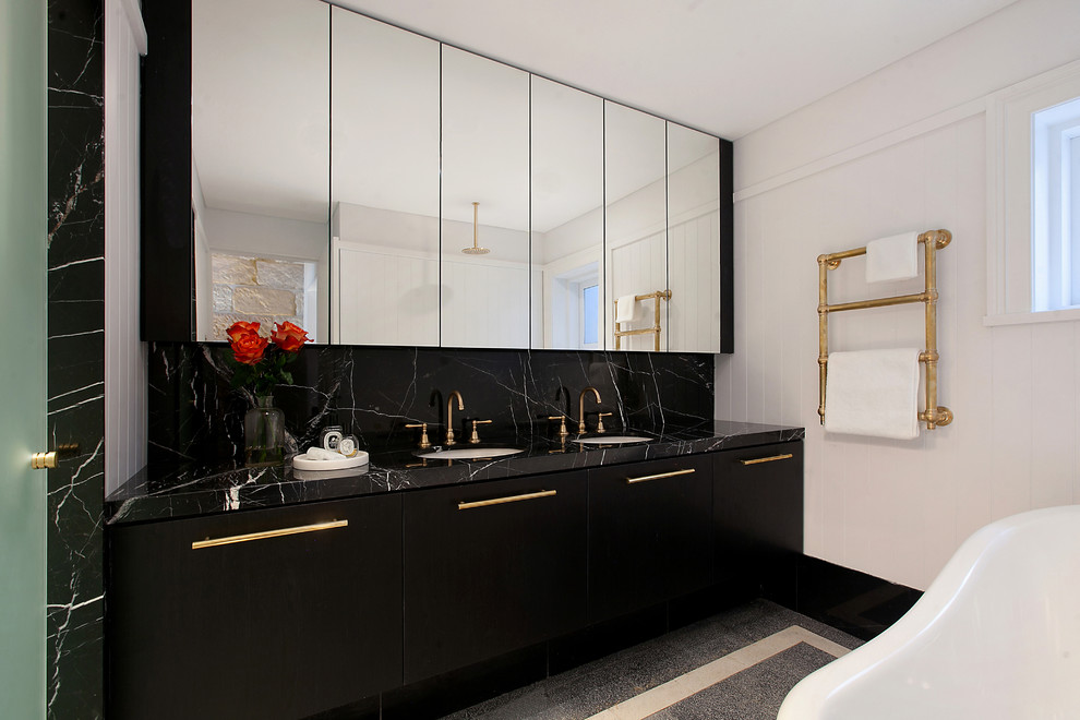 This is an example of a small contemporary master bathroom in Sydney with black cabinets, a claw-foot tub, a shower/bathtub combo, white tile, porcelain tile, white walls, marble floors, an integrated sink, marble benchtops, black floor, an open shower and black benchtops.