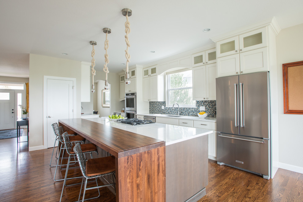 Photo of a large beach style single-wall eat-in kitchen in Denver with an undermount sink, shaker cabinets, white cabinets, quartzite benchtops, blue splashback, mosaic tile splashback, stainless steel appliances, medium hardwood floors, with island and brown floor.