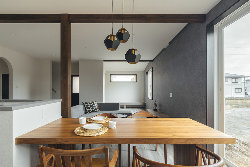 Cette image montre une petite salle à manger ouverte sur le salon avec un mur gris, un plafond en papier peint, du papier peint et éclairage.