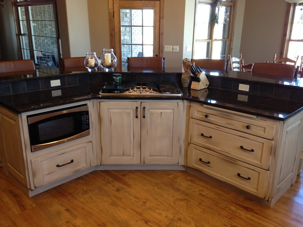 Inspiration for a mid-sized rustic single-wall medium tone wood floor and brown floor eat-in kitchen remodel with raised-panel cabinets, light wood cabinets, granite countertops, stainless steel appliances and an island
