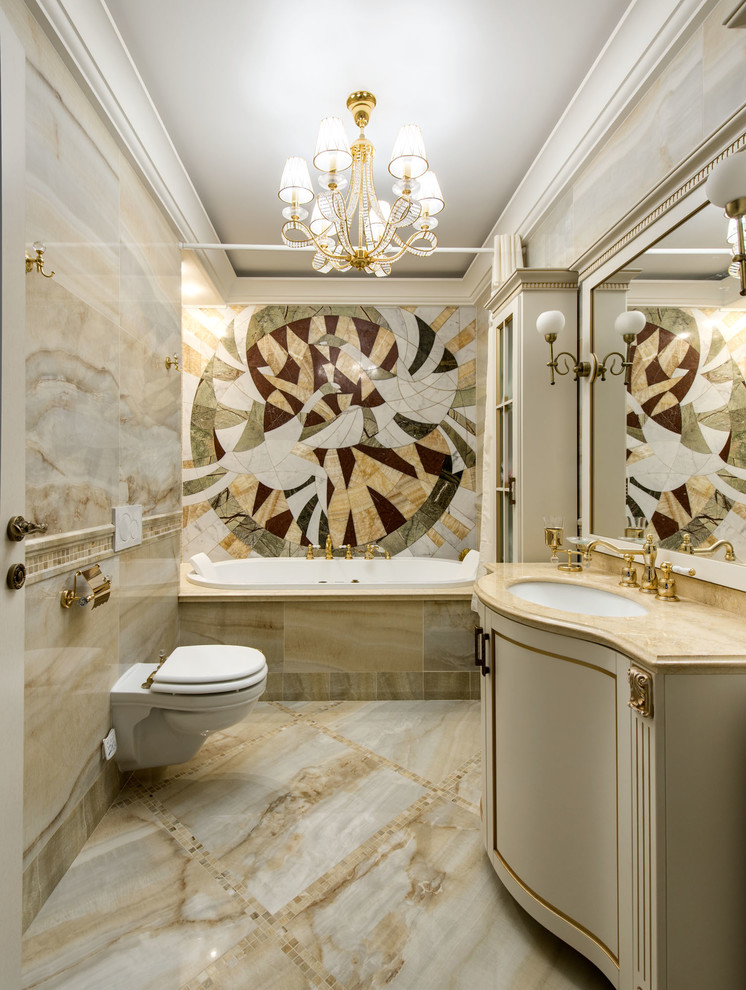 Photo of a traditional master bathroom in Moscow with a drop-in tub, a wall-mount toilet, beige tile, an undermount sink, beige floor and beige benchtops.