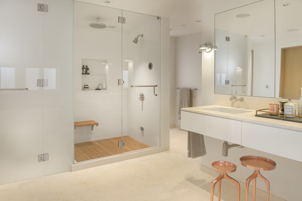 This is an example of a contemporary master bathroom in San Francisco with flat-panel cabinets, white cabinets, an alcove shower, white walls, an undermount sink, beige floor and a hinged shower door.