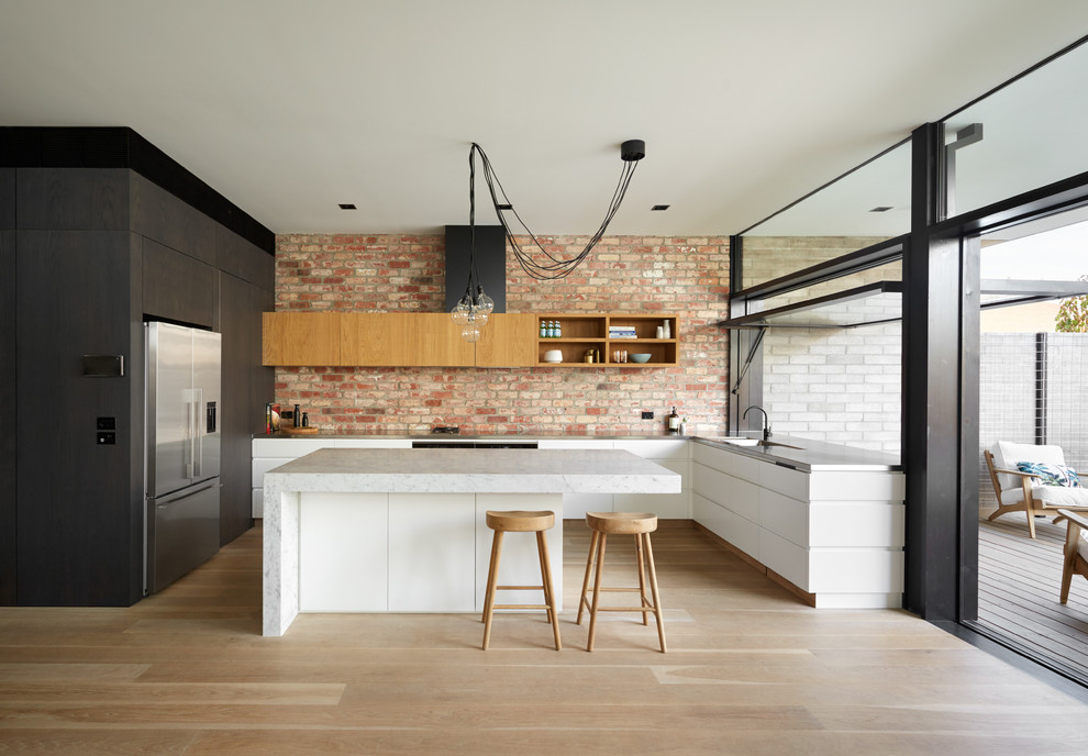 Design ideas for a large transitional l-shaped kitchen pantry in Melbourne with a double-bowl sink, beaded inset cabinets, black cabinets, marble benchtops, brick splashback and with island.