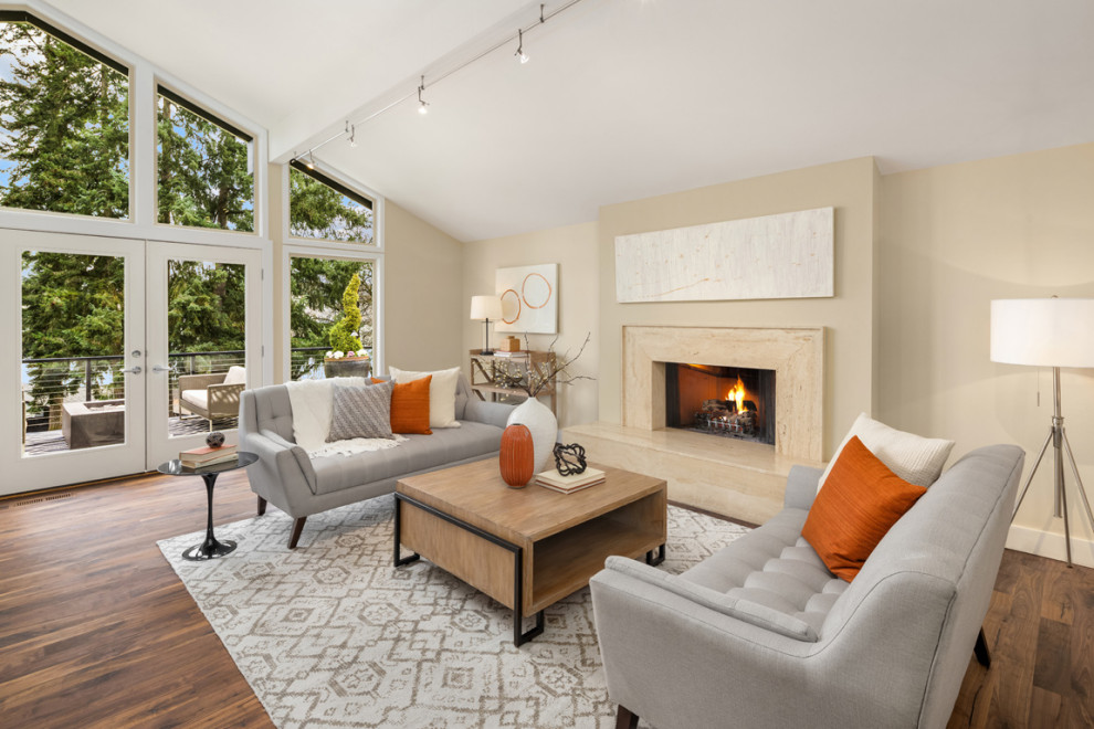 Design ideas for a medium sized contemporary open plan living room in Seattle with dark hardwood flooring, a standard fireplace, brown floors and a vaulted ceiling.
