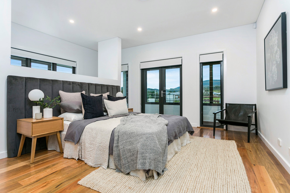 Photo of a large country master bedroom in Wollongong with medium hardwood floors.