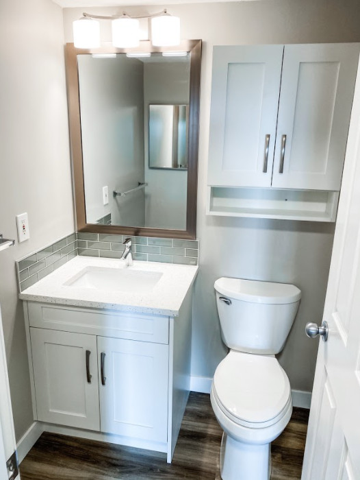 Design ideas for a small modern master bathroom in Calgary with recessed-panel cabinets, white cabinets, a drop-in tub, a shower/bathtub combo, a one-piece toilet, gray tile, subway tile, beige walls, an integrated sink, quartzite benchtops, a shower curtain, white benchtops, a single vanity and a built-in vanity.