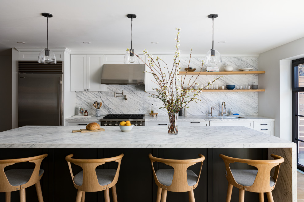 Inspiration for a large transitional single-wall separate kitchen in Austin with a drop-in sink, shaker cabinets, white cabinets, marble benchtops, grey splashback, marble splashback, stainless steel appliances, light hardwood floors, with island, beige floor and grey benchtop.
