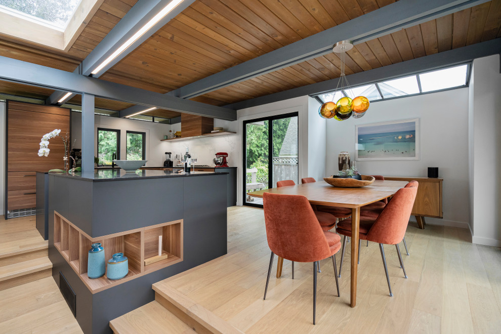 Photo of a midcentury open plan dining in Los Angeles with white walls, light hardwood floors and beige floor.