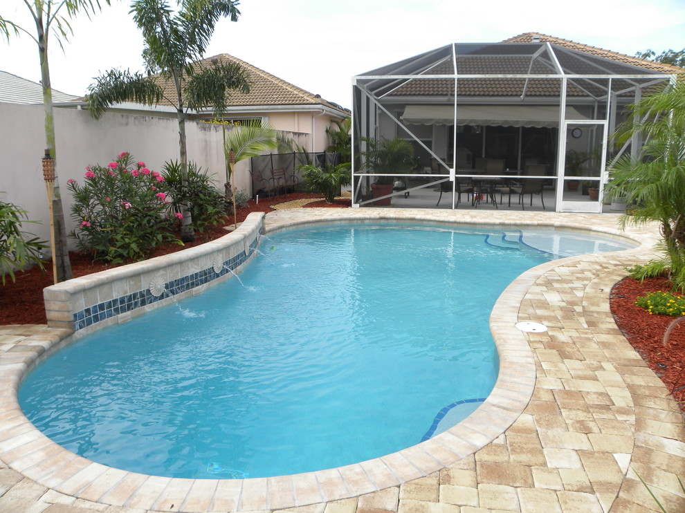 Photo of a small contemporary custom-shaped pool in Miami with decking.