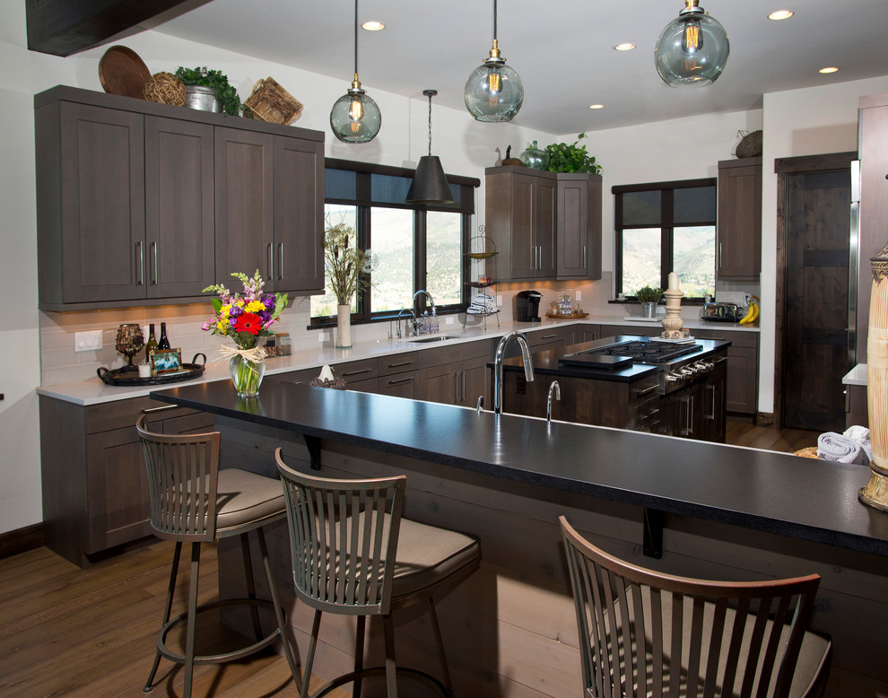 Eat-in kitchen - large transitional u-shaped medium tone wood floor eat-in kitchen idea in Denver with an undermount sink, recessed-panel cabinets, gray cabinets, quartz countertops, white backsplash, ceramic backsplash, stainless steel appliances and two islands