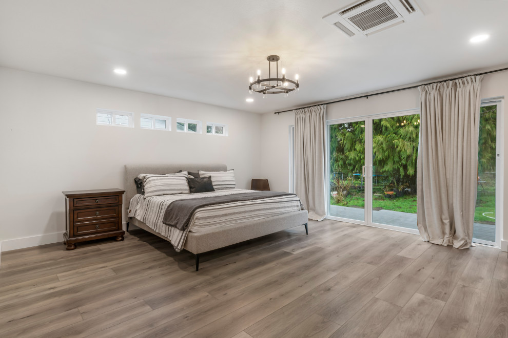 Diseño de dormitorio principal moderno de tamaño medio con paredes blancas, suelo vinílico y suelo marrón