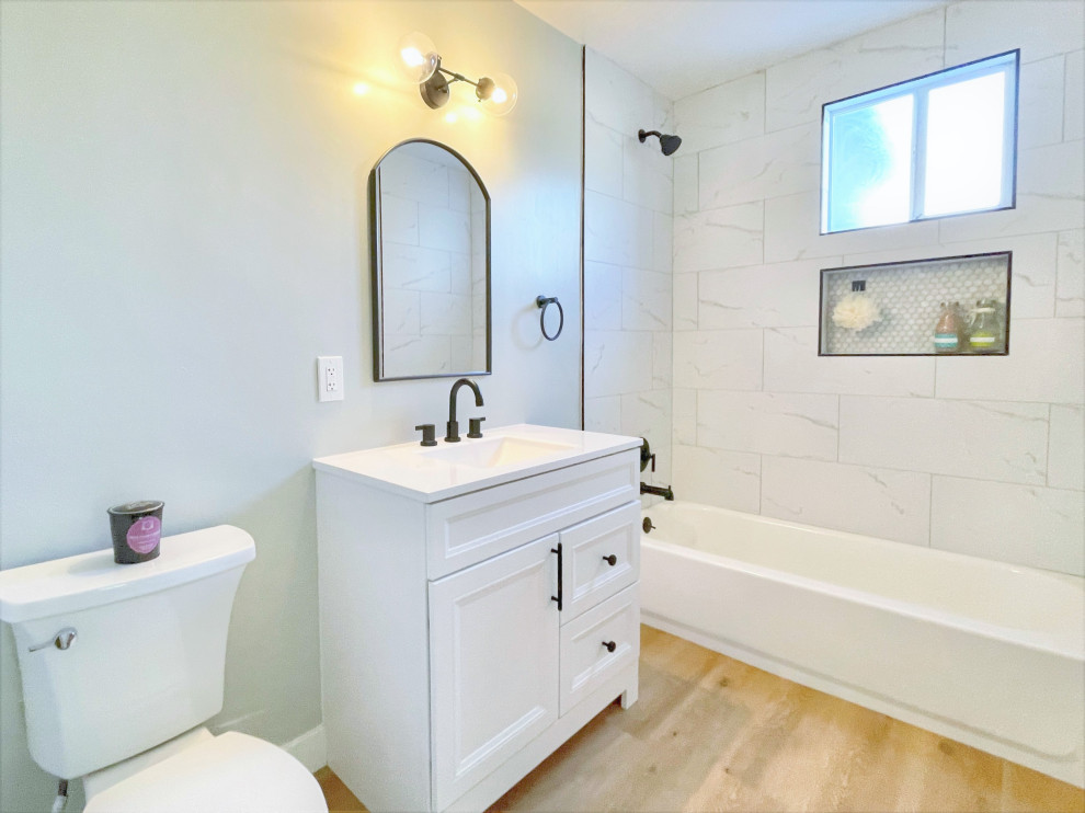 Пример оригинального дизайна: маленькая ванная комната в стиле модернизм с фасадами в стиле шейкер, белыми фасадами, ванной в нише, душем в нише, раздельным унитазом, белой плиткой, керамогранитной плиткой, зелеными стенами, полом из винила, монолитной раковиной, столешницей из искусственного кварца, бежевым полом, шторкой для ванной, белой столешницей, нишей, тумбой под одну раковину и напольной тумбой для на участке и в саду