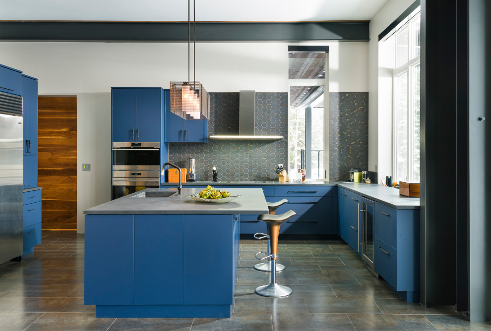 Photo of a large contemporary u-shaped separate kitchen in Other with a drop-in sink, flat-panel cabinets, blue cabinets, concrete benchtops, grey splashback, mosaic tile splashback, stainless steel appliances, ceramic floors, with island, grey benchtop and grey floor.