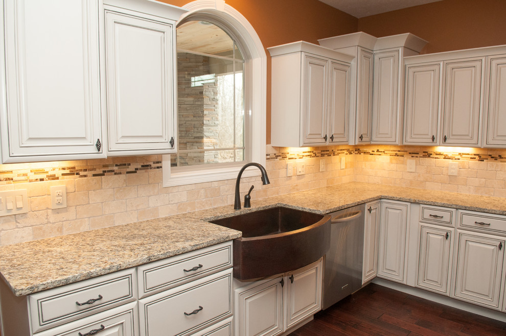 Open concept kitchen - large contemporary l-shaped dark wood floor and brown floor open concept kitchen idea with beaded inset cabinets, white cabinets, an island, a farmhouse sink, granite countertops, beige backsplash, stone tile backsplash and stainless steel appliances