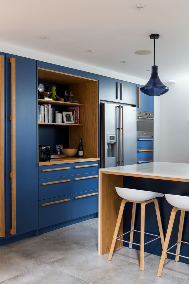 Inspiration for a large contemporary u-shaped eat-in kitchen in Surrey with flat-panel cabinets, blue cabinets, stainless steel appliances, with island, an undermount sink, quartzite benchtops, metallic splashback, metal splashback, ceramic floors and beige floor.