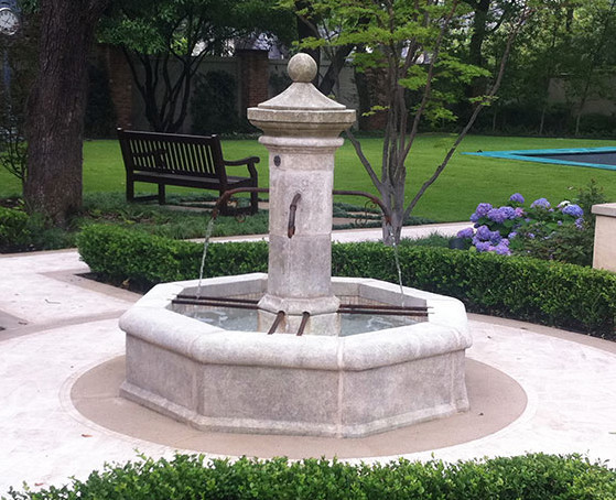 Photo of a mid-sized mediterranean backyard formal garden in Dallas with a water feature and natural stone pavers.