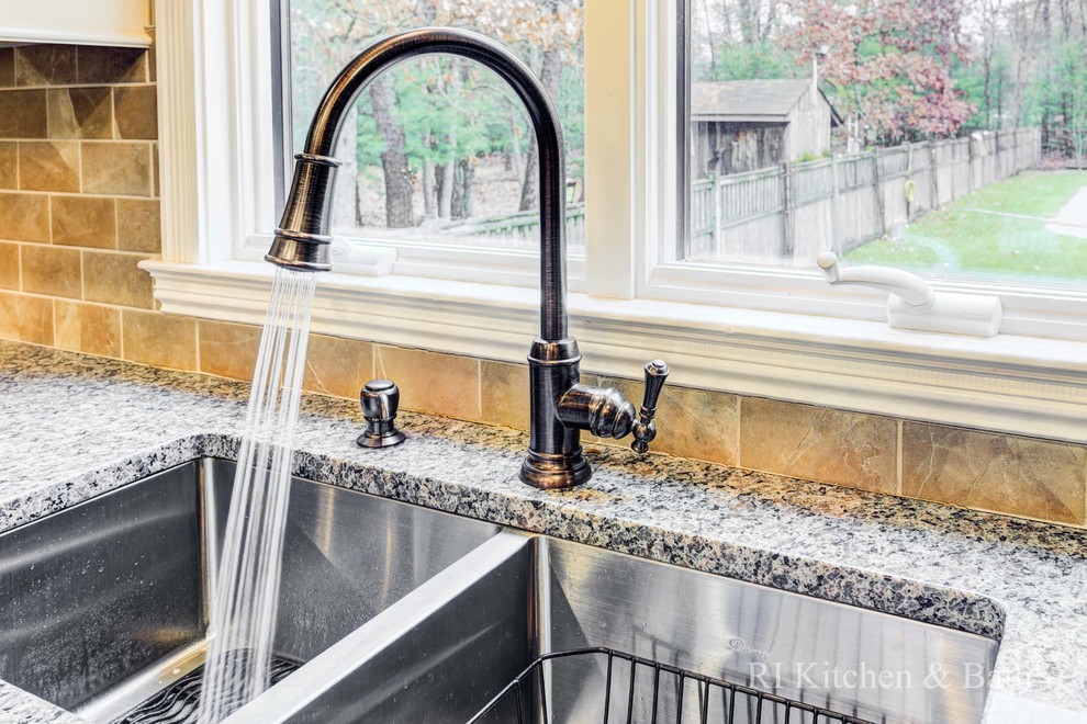 Inspiration for a large transitional u-shaped light wood floor eat-in kitchen remodel in Providence with an undermount sink, shaker cabinets, beige cabinets, granite countertops, brown backsplash, porcelain backsplash, stainless steel appliances and an island