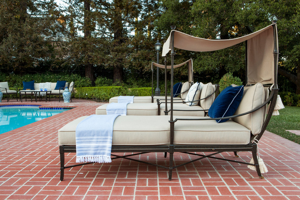 Large transitional backyard brick and rectangular pool photo in Los Angeles