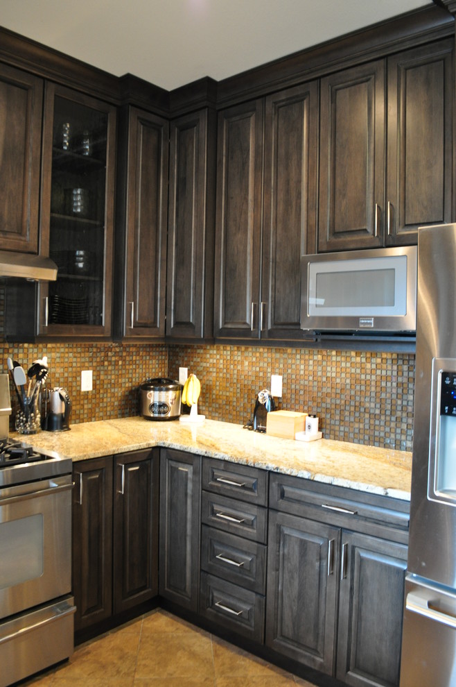 Inspiration for a mid-sized transitional l-shaped porcelain tile eat-in kitchen remodel in Seattle with an undermount sink, raised-panel cabinets, gray cabinets, granite countertops, multicolored backsplash, mosaic tile backsplash, stainless steel appliances and no island