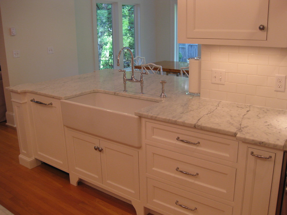 Eat-in kitchen - transitional u-shaped medium tone wood floor eat-in kitchen idea in Boston with a farmhouse sink, beaded inset cabinets, white cabinets, marble countertops, white backsplash, subway tile backsplash, stainless steel appliances and an island
