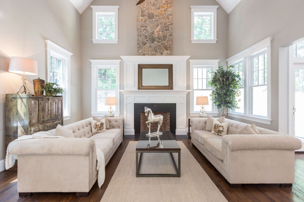 Photo of a transitional formal enclosed living room in Boston with beige walls, medium hardwood floors, a standard fireplace, a brick fireplace surround, no tv and brown floor.