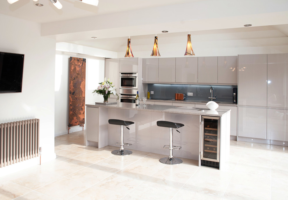 This is an example of a large contemporary kitchen/diner in Essex with a submerged sink, flat-panel cabinets, engineered stone countertops, grey splashback, glass sheet splashback, stainless steel appliances, ceramic flooring and an island.