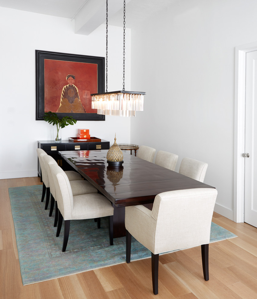 This is an example of a mid-sized contemporary dining room in New York with white walls, light hardwood floors and beige floor.