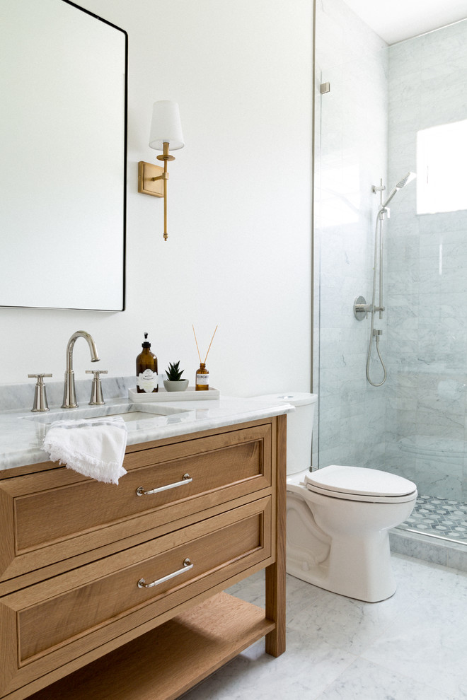 Design ideas for a mid-sized transitional 3/4 bathroom in Toronto with beaded inset cabinets, light wood cabinets, an open shower, a one-piece toilet, gray tile, porcelain tile, white walls, porcelain floors, an undermount sink, engineered quartz benchtops, white floor, a hinged shower door and white benchtops.