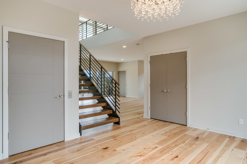 This is an example of a large foyer in Seattle with light hardwood floors, beige walls, a light wood front door and a single front door.