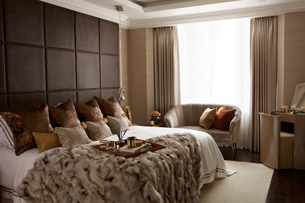 This is an example of a contemporary master bedroom in London with beige walls, dark hardwood floors and brown floor.