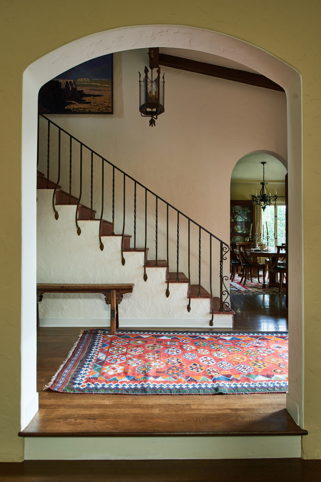 Inspiration for a mid-sized mediterranean foyer in Los Angeles with beige walls, dark hardwood floors and brown floor.
