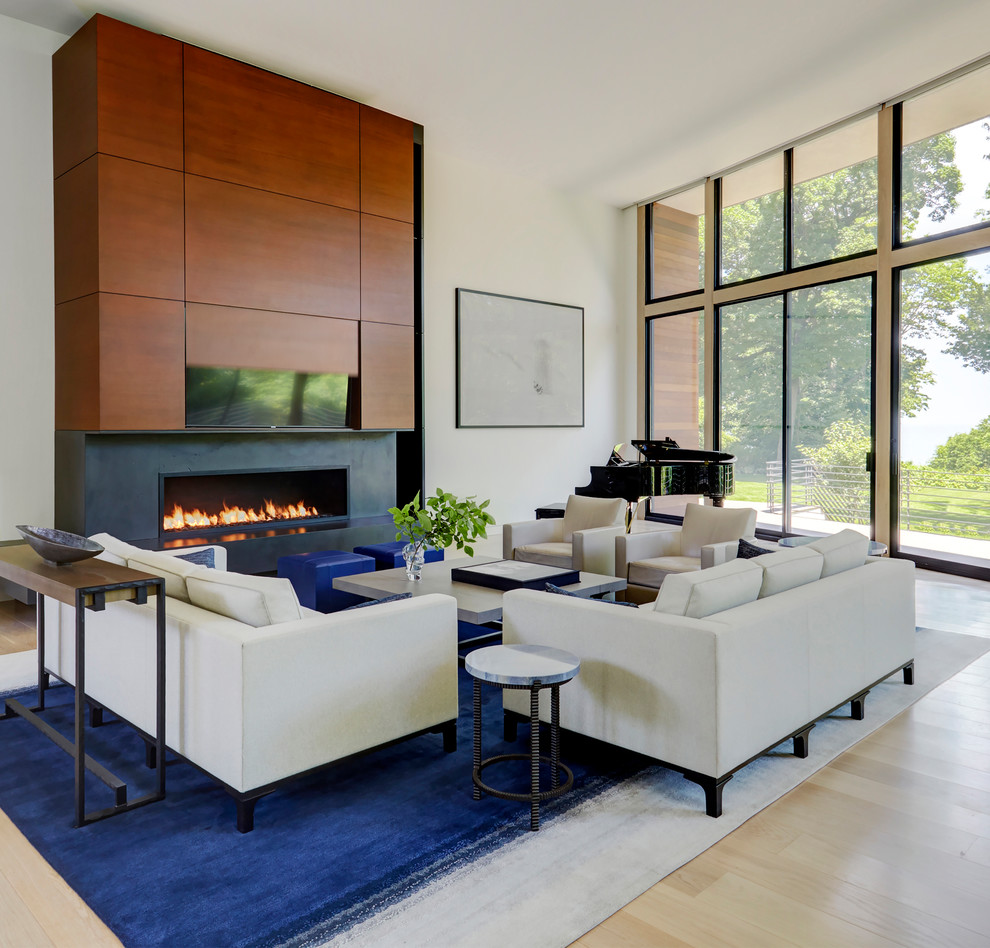 Photo of a contemporary open concept living room in Chicago with a music area, white walls, light hardwood floors, a ribbon fireplace and beige floor.