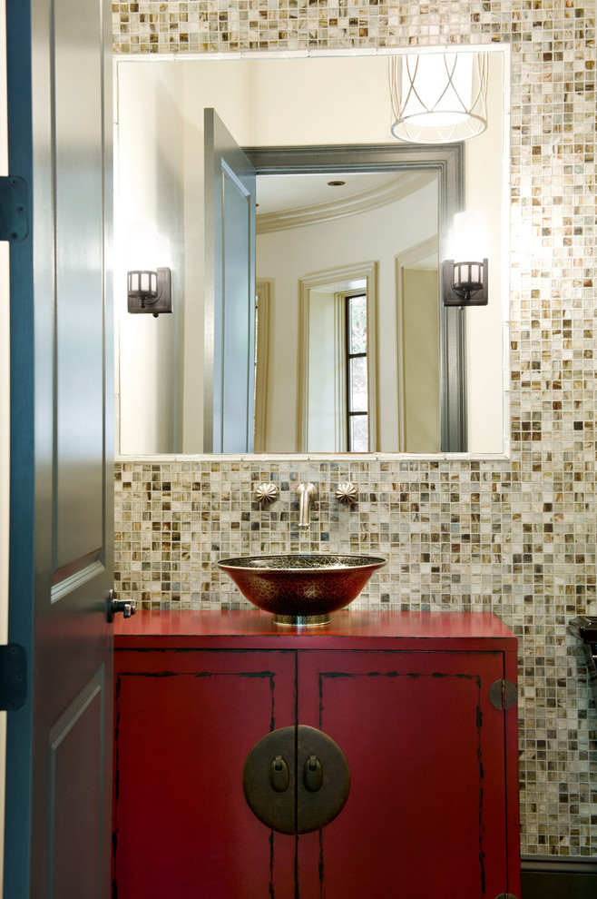 This is an example of a transitional powder room in Other with furniture-like cabinets, a two-piece toilet, glass tile, a vessel sink, wood benchtops, red cabinets, multi-coloured tile, multi-coloured walls and red benchtops.