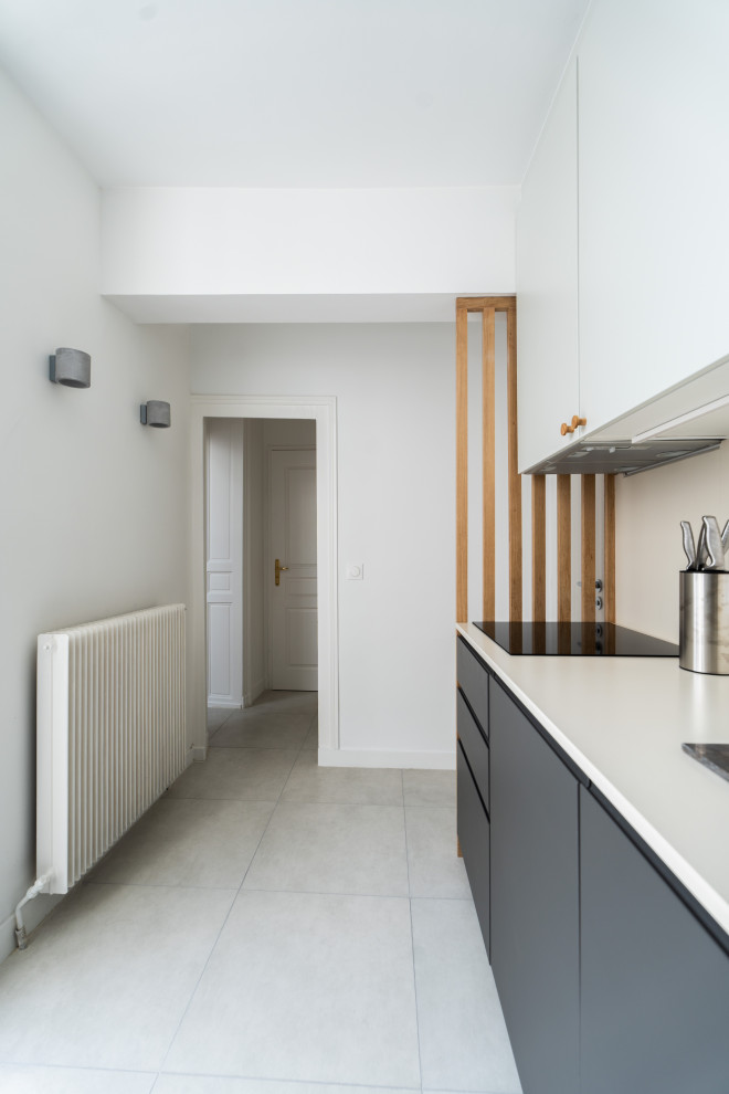 Inredning av ett modernt mellanstort vit vitt kök, med en undermonterad diskho, luckor med infälld panel, grå skåp, beige stänkskydd, integrerade vitvaror och grått golv
