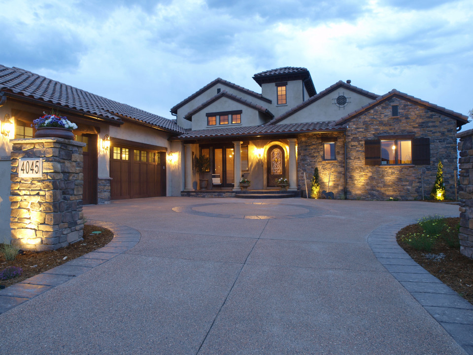 Design ideas for a large mediterranean two-storey exterior in Denver with stone veneer.