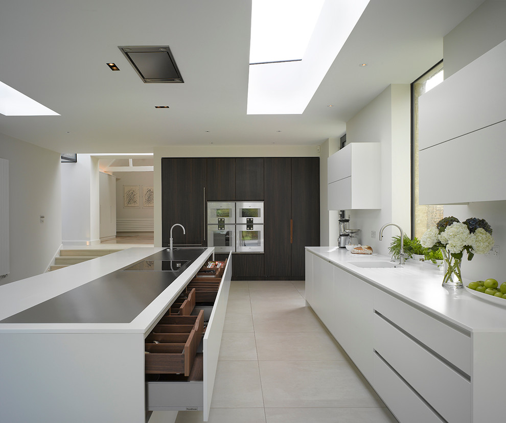 Large modern l-shaped eat-in kitchen in London with flat-panel cabinets, white cabinets, solid surface benchtops, white splashback and with island.
