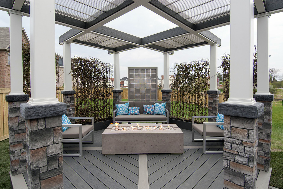 Inspiration for a mid-sized industrial backyard deck in Toronto with a fire feature and a pergola.