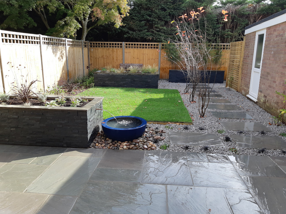 This is an example of a small contemporary backyard full sun garden in Oxfordshire with natural stone pavers.