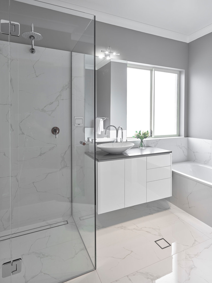 Inspiration for a large transitional master bathroom in Other with flat-panel cabinets, white cabinets, a drop-in tub, an open shower, a two-piece toilet, white tile, porcelain tile, grey walls, porcelain floors, a vessel sink, engineered quartz benchtops, white floor, an open shower and grey benchtops.