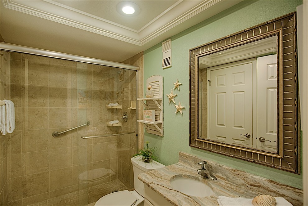 Mid-sized beach style bathroom in Tampa with raised-panel cabinets, light wood cabinets and ceramic floors.
