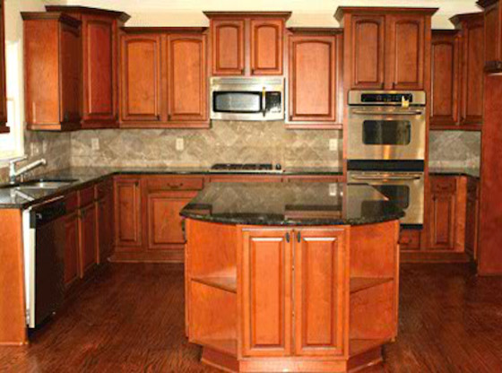 Cette photo montre une cuisine en bois brun avec un plan de travail en granite, un électroménager en acier inoxydable, un sol en bois brun et îlot.