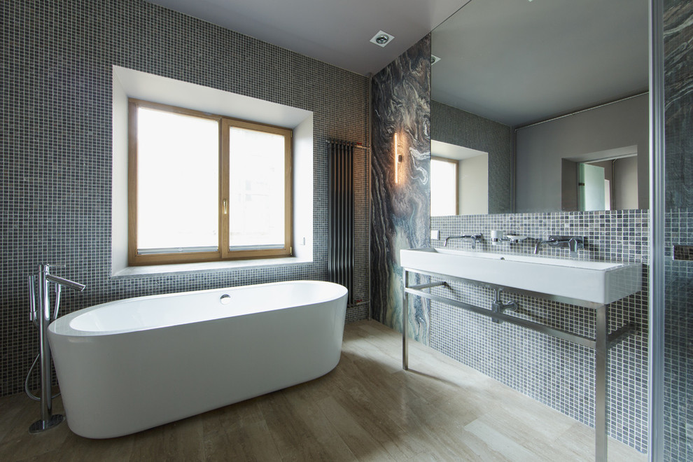 Photo of a contemporary master bathroom in Other with a freestanding tub, gray tile, mosaic tile and a trough sink.