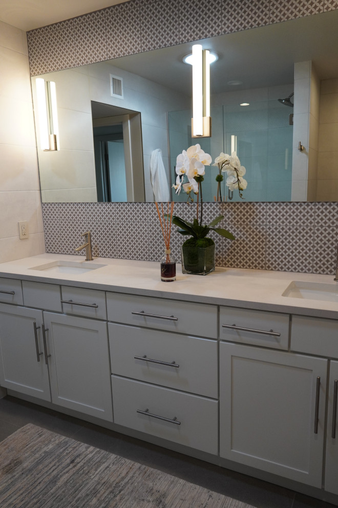 Exemple d'une salle de bain rétro avec des portes de placard blanches, une baignoire posée, WC séparés, un carrelage beige, des carreaux de céramique, un mur beige, un sol en carrelage de céramique, un lavabo encastré, un plan de toilette en quartz modifié, un sol gris, une cabine de douche à porte battante, un plan de toilette blanc, meuble double vasque et meuble-lavabo encastré.