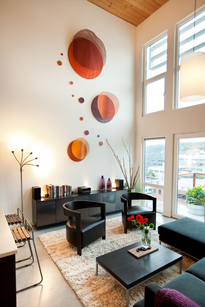 Photo of an industrial living room in Seattle with white walls and concrete floors.