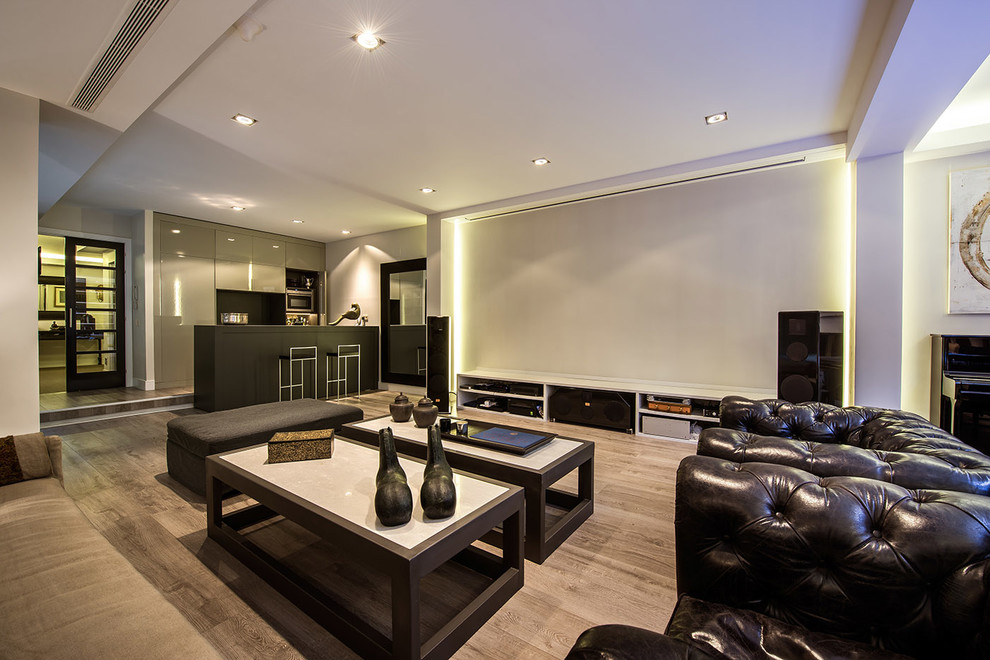 Large modern open concept home theatre in Madrid with white walls, medium hardwood floors and a projector screen.