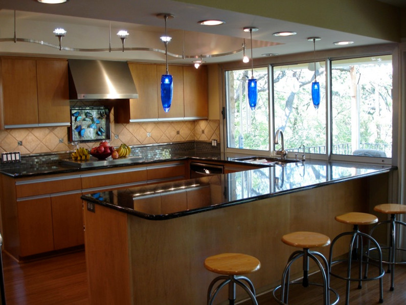 Inspiration for a transitional u-shaped kitchen pantry remodel in Austin with flat-panel cabinets, dark wood cabinets, beige backsplash, stainless steel appliances and no island