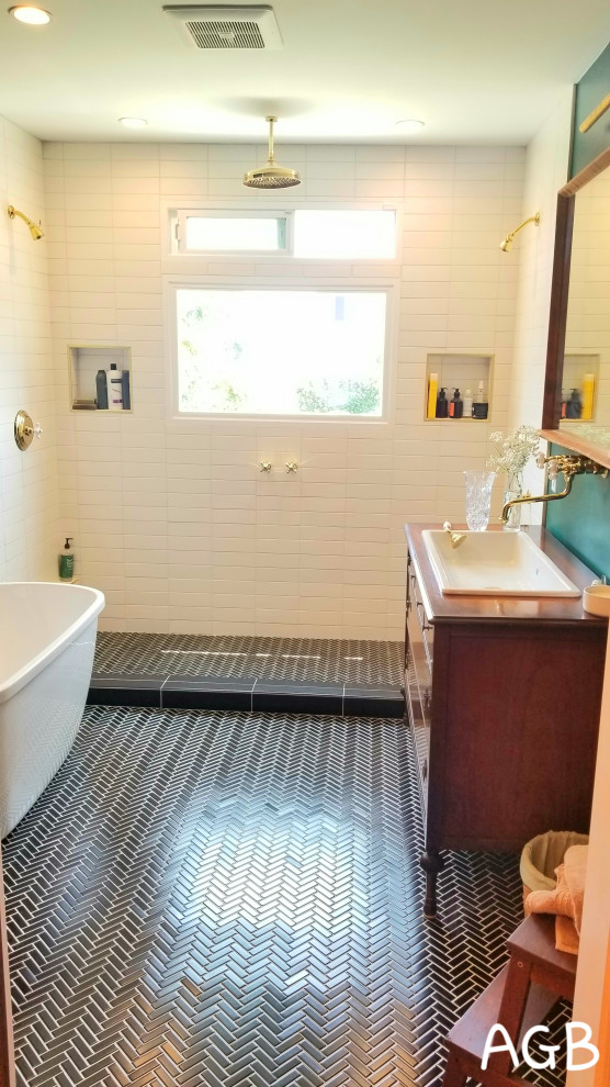 This is an example of a mid-sized midcentury master bathroom in Los Angeles with raised-panel cabinets, brown cabinets, a freestanding tub, a double shower, a one-piece toilet, white tile, ceramic tile, green walls, porcelain floors, a drop-in sink, wood benchtops, black floor, a sliding shower screen, brown benchtops and a single vanity.