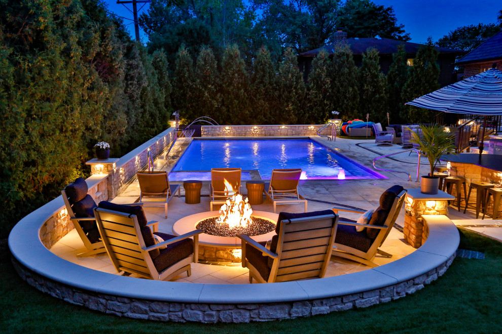 Example of a mid-sized classic backyard stone and rectangular lap and privacy pool design in Chicago